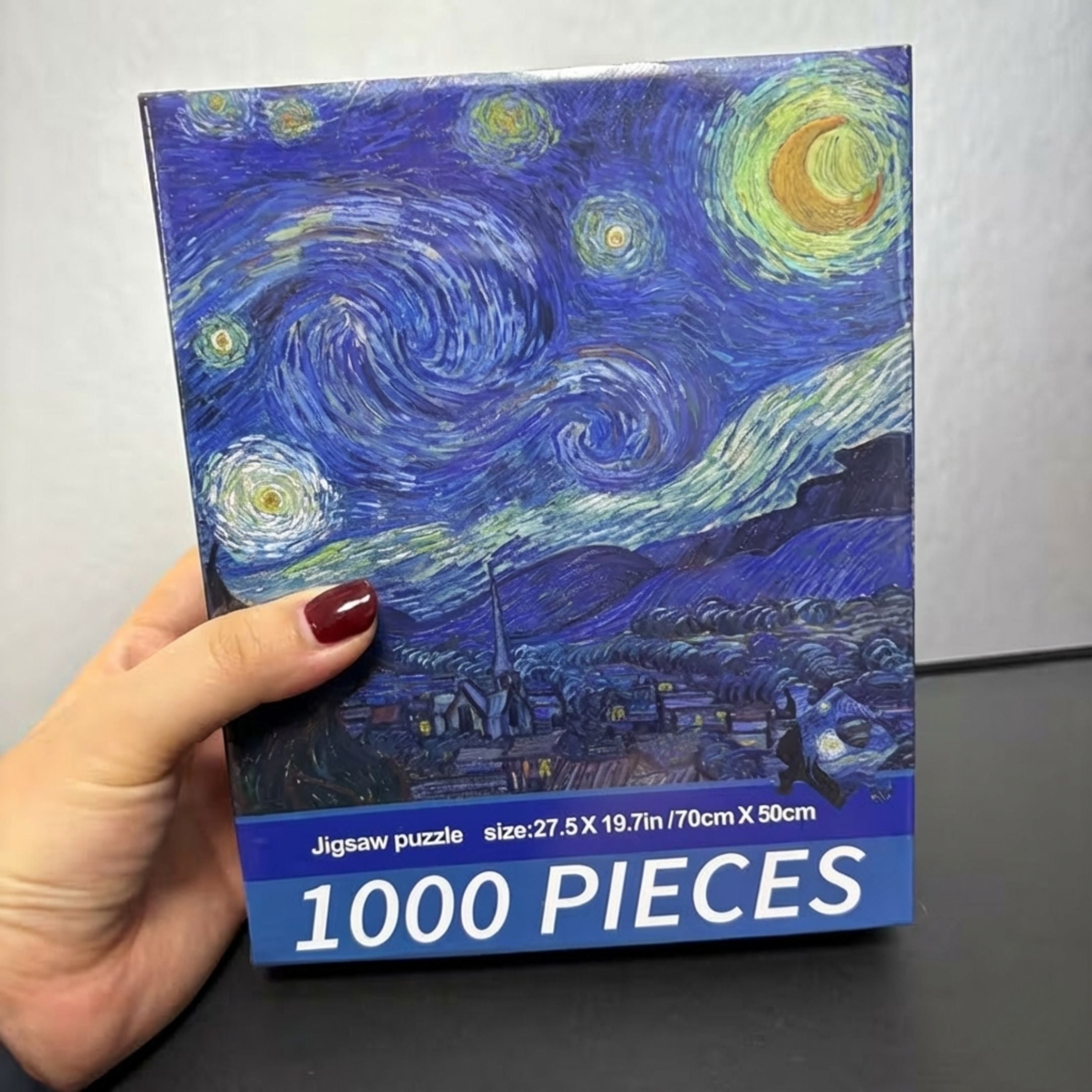 Кутия на пъзел 1000 части „Звездна нощ“ от Ван Гог, държана в ръка за мащаб