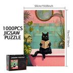 Пъзел от 1000 части с художествена илюстрация на черна котка, седнала във вана и държаща книга, разположена в интериор с пастелни розови и тюркоазени плочки, декоративни растения и кръгло огледало, с ясно обозначени размери 50x70 см и показана опаковка на продукта.