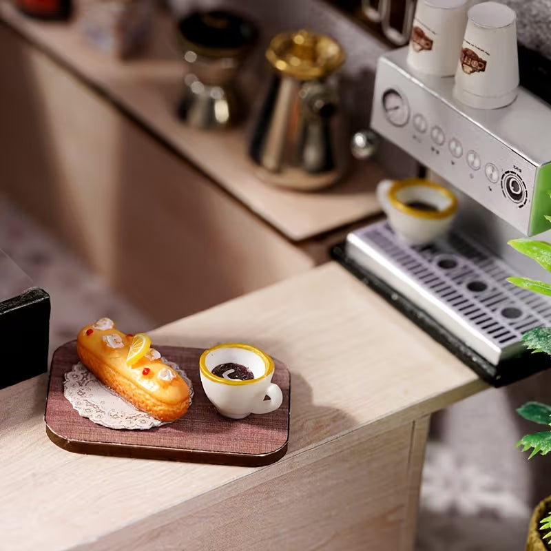 Миниатюрно кафе еспресо с десерт върху дървен поднос, до малка кафе машина, детайл от DIY кафе сцена