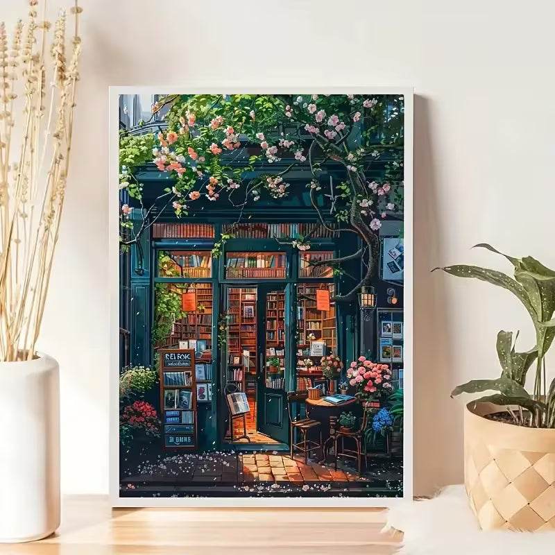 Декоративна картина в рамка с илюстрация на уютна книжарница с отворена врата, рафтове с книги и цъфнали цветя отпред, подходяща за интериор и подарък.