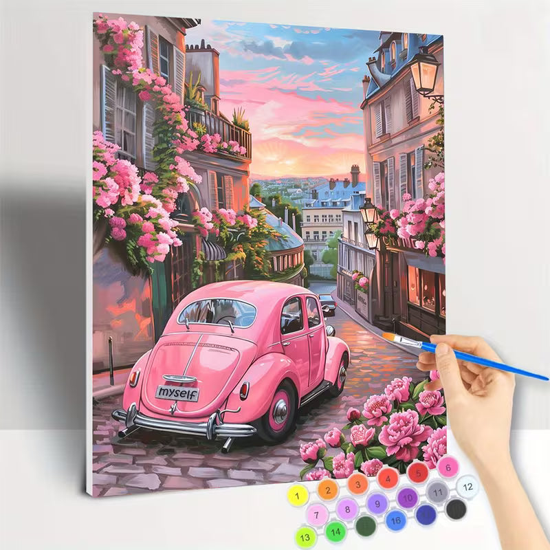 Картина за оцветяване по номера с  романтична сцена на уличка с розова ретро кола и цъфнали цветя, показан в процес на изработка с апликатор и цветни мъниста.