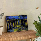 Скреч картина по Ван Гог „Мостът над Сена“, изложена върху маса в интериор